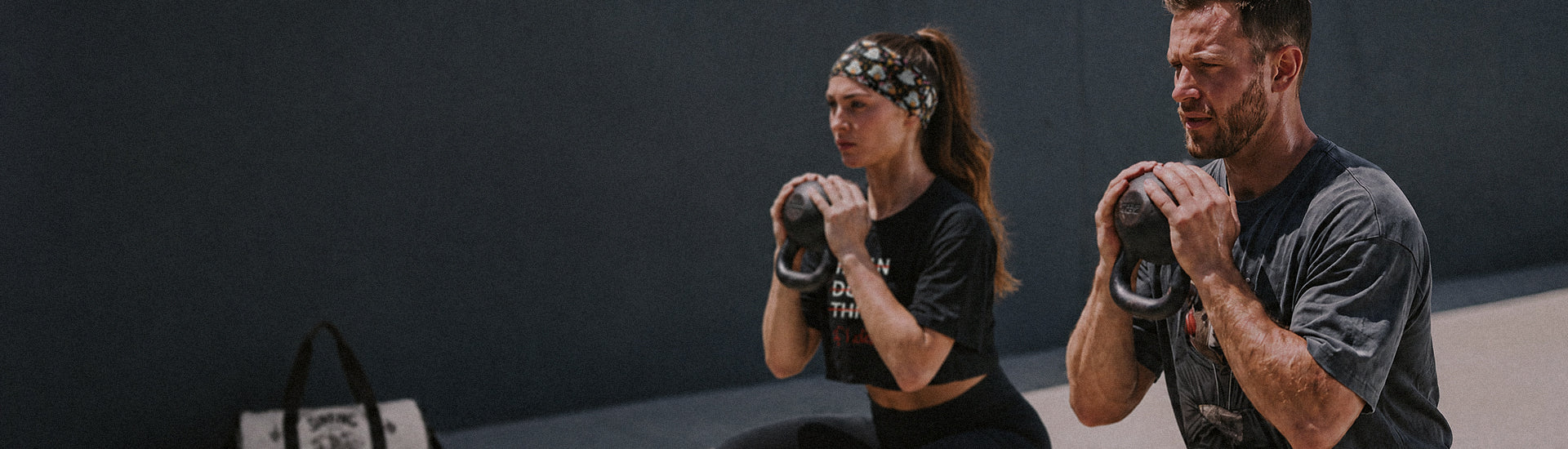 Athletes training with kettlebells in graphic gym clothing